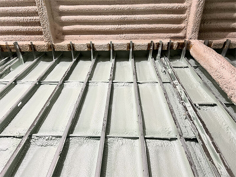 Green Spray foam insulation applied to prefab metal panel in Utica, New York